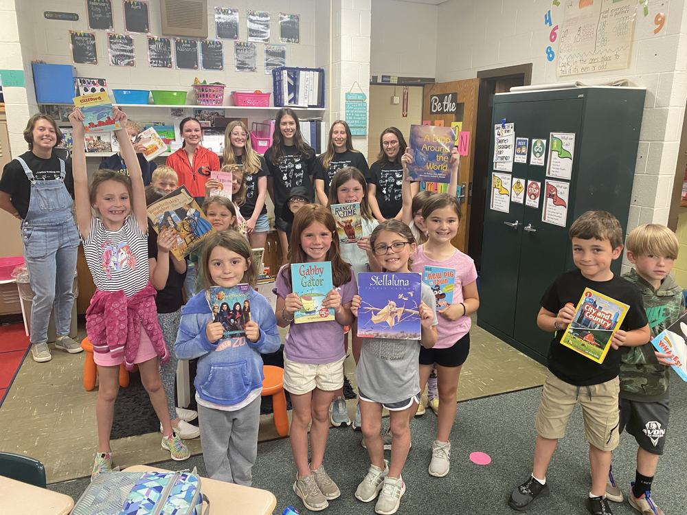 Avon Elementary School students pose for a photo with the books students in Mrs. Cordula Kennell’s creative writing collected during a book drive earlier this year. 
