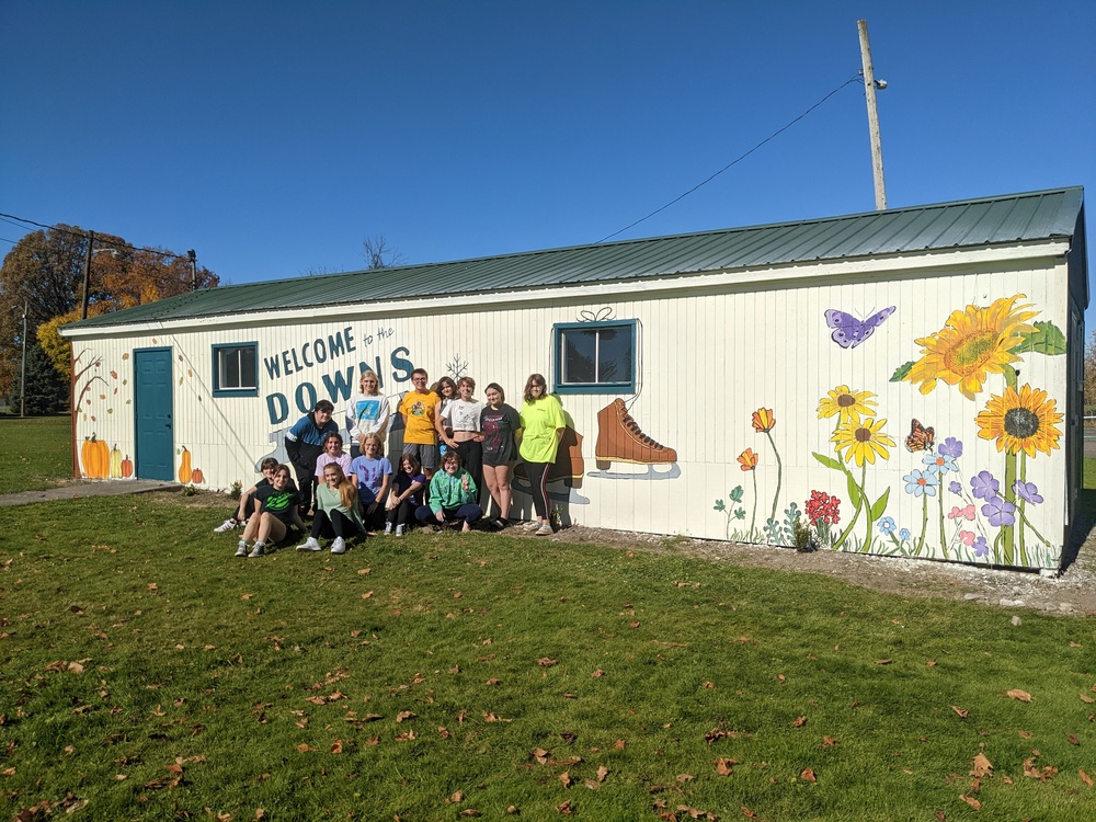 Members of the High School Art Club work on their mural on an exterior wall of the Skate Shack at the Avon Driving Park. The mural features a seasonal motif and was officially unveiled during a ceremony in December. 